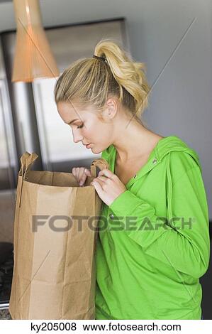 Woman looking into a paper bag View Large Photo Image Stock Photo - Woman looking into a paper bag. Fotosearch