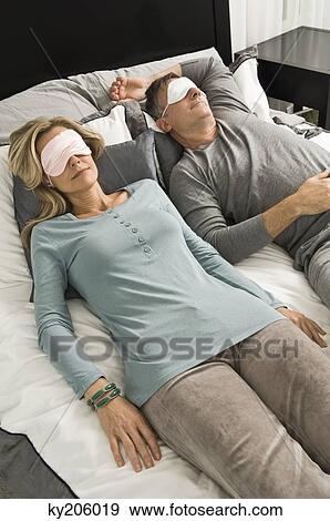 Couple sleeping in bed wearing eye masks View Large Photo Image Stock Photo - Couple sleeping in bed wearing eye masks. Fotosearch