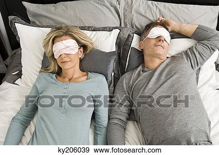 Couple sleeping in bed wearing eye masks View Large Photo Image Stock Photo - Couple sleeping in bed wearing eye masks. Fotosearch