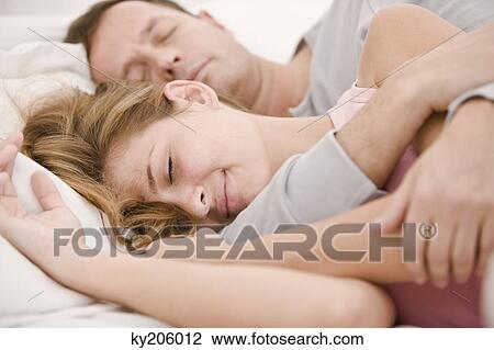 Couple sleeping on the bed View Large Photo Image Stock Image - Couple sleeping on the bed. Fotosearch