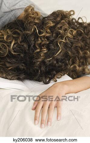 Girl sleeping with her face down on a book View Large Photo Image Stock Photo - Girl sleeping with her face down on a book. Fotosearch