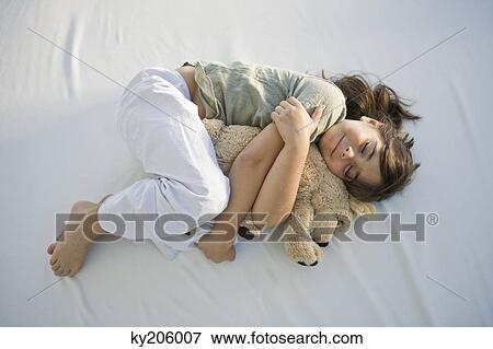 High angle view of a girl sleeping with a teddy bear View Large Photo Image Stock Photo - High angle view of a girl sleeping with a teddy bear. Fotosearch