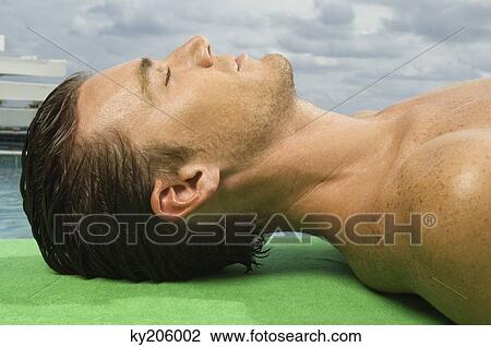 Man resting at the poolside View Large Photo Image Stock Image - Man resting at the poolside. Fotosearch