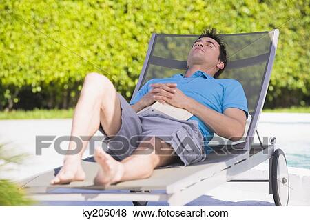 Man resting on a lounge chair View Large Photo Image Stock Photo - Man resting on a lounge chair. Fotosearch