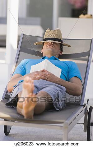 Stock Image - Man sleeping on a lounge chair. Fotosearch