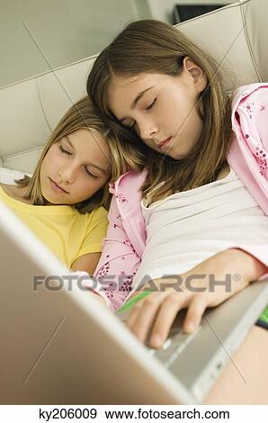 Two girls sleeping with a laptop on their laps View Large Photo Image Stock Photo - Two girls sleeping with a laptop on their laps. Fotosearch