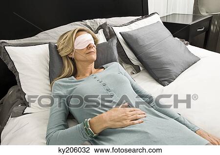 Woman sleeping in bed wearing an eye mask View Large Photo Image Stock Image - Woman sleeping in bed wearing an eye mask. Fotosearch