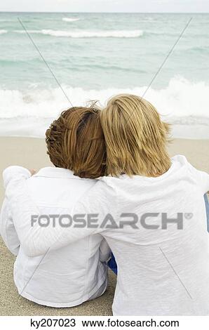 Teenage boy sitting with his grandmother on the beach View Large Photo Image Stock Image - Teenage boy sitting with his grandmother on the beach. Fotosearch