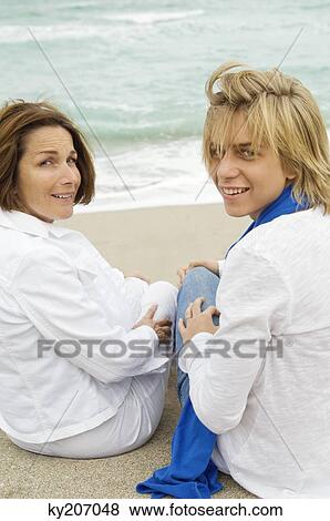 Teenage boy sitting with his grandmother on the beach View Large Photo Image Stock Photo - Teenage boy sitting with his grandmother on the beach. Fotosearch