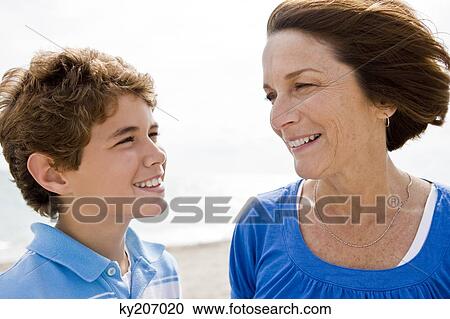 Woman and her grandson looking at each other and smiling View Large Photo Image Stock Image - Woman and her grandson looking at each other and smiling. Fotosearch