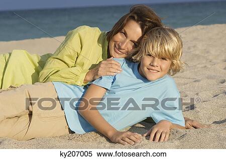 Woman lying with her grandson on the beach View Large Photo Image Stock Photography - Woman lying with her grandson on the beach. Fotosearch