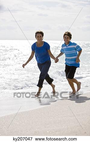 Woman running on the beach with her grandson View Large Photo Image Stock Photo - Woman running on the beach with her grandson. Fotosearch
