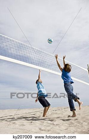 Stock Photo - Woman with her grandson playing beach volleyball. Fotosearch