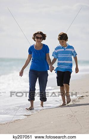 Woman with her grandson walking on the beach View Large Photo Image Stock Image - Woman with her grandson walking on the beach. Fotosearch