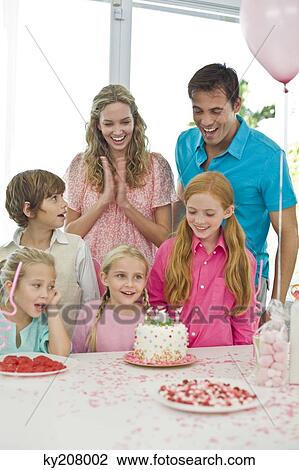 Girl celebrating her birthday with her parents and friends View Large Photo Image Stock Image - Girl celebrating her birthday with her parents and friends. Fotosearch