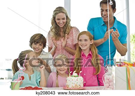 Girl celebrating her birthday with her parents and friends View Large Photo Image Stock Image - Girl celebrating her birthday with her parents and friends. Fotosearch