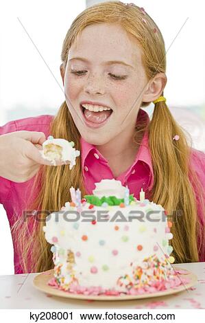 Stock Image - Girl eating birthday cake. Fotosearch