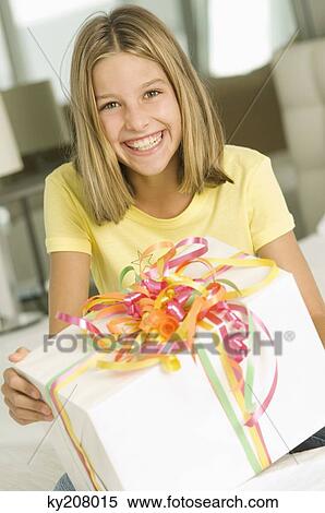 Girl holding a birthday present and smiling View Large Photo Image Stock Photography - Girl holding a birthday present and smiling. Fotosearch