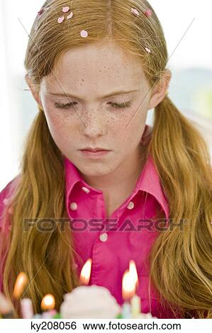 Girl looking at a birthday cake View Large Photo Image Stock Photograph - Girl looking at a birthday cake. Fotosearch