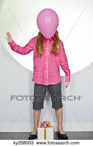 Pink balloon tied with a birthday present in front of a girl's face View Large Photo Image Stock Image - Pink balloon tied with a birthday present in front of a girl's face. Fotosearch