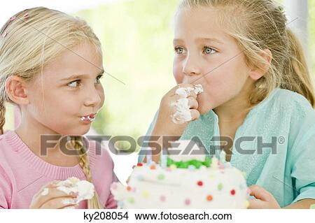 Two girls eating birthday cake View Large Photo Image Picture - Two girls eating birthday cake. Fotosearch