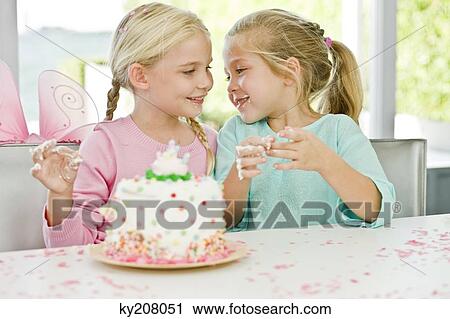 Stock Image - Two girls enjoying a birthday party. Fotosearch