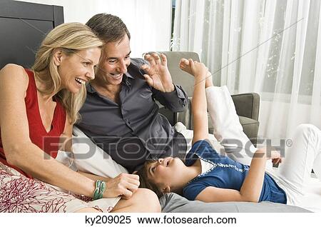 Girl having fun with her parents View Large Photo Image Stock Photography - Girl having fun with her parents. Fotosearch