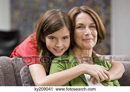 Girl hugging her grandmother from behind View Large Photo Image Stock Image - Girl hugging her grandmother from behind. Fotosearch