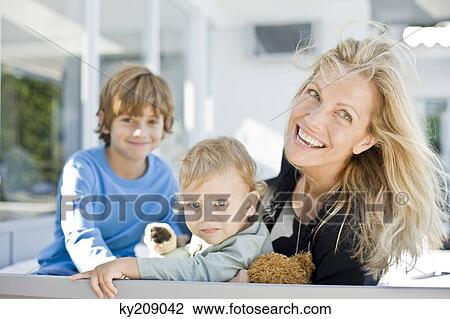 Portrait of a woman smiling with her two sons View Large Photo Image Stock Image - Portrait of a woman smiling with her two sons. Fotosearch