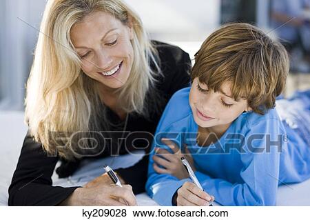 Woman helping her son in his homework View Large Photo Image Stock Photo - Woman helping her son in his homework. Fotosearch
