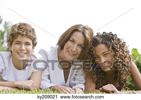 Woman lying on grass with her grandchildren View Large Photo Image Stock Image - Woman lying on grass with her grandchildren. Fotosearch