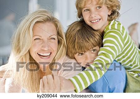 Woman smiling with her two sons View Large Photo Image Picture - Woman smiling with her two sons. Fotosearch