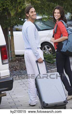 Couple holding luggage and smiling View Large Photo Image Stock Photography - Couple holding luggage and smiling. Fotosearch