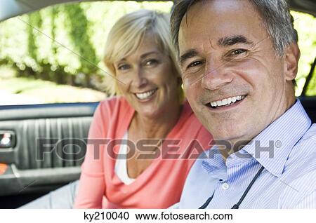 Couple in a car and smiling View Large Photo Image Stock Image - Couple in a car and smiling. Fotosearch