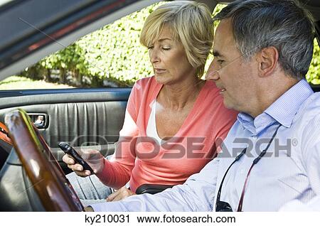 Couple in a car and text messaging View Large Photo Image Stock Image - Couple in a car and text messaging. Fotosearch