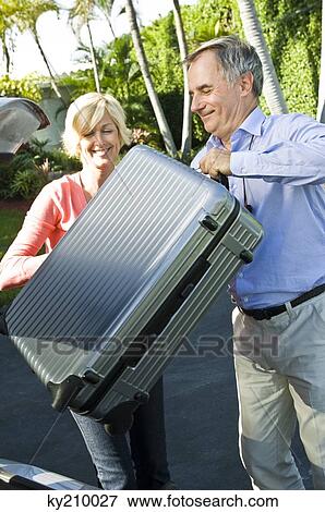 Couple loading luggage into a car View Large Photo Image Stock Photo - Couple loading luggage into a car. Fotosearch