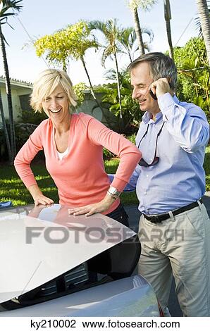 Couple standing at the back side of a car View Large Photo Image Stock Image - Couple standing at the back side of a car. Fotosearch