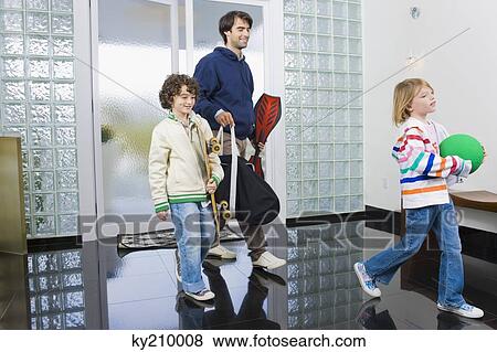 Stock Photo - Man entering the house with his children. Fotosearch