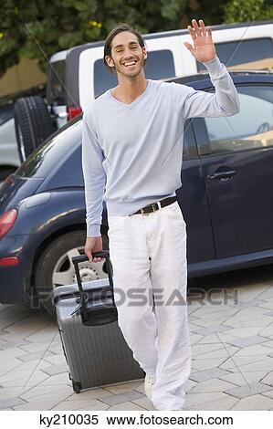 Man pulling luggage and waving hand View Large Photo Image Stock Photography - Man pulling luggage and waving hand. Fotosearch