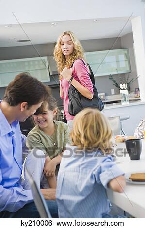 Woman standing beside her family having breakfast View Large Photo Image Stock Photograph - Woman standing beside her family having breakfast. Fotosearch