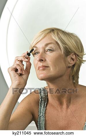 Stock Photography - Close-up of a woman applying mascara on her eyelash. Fotosearch