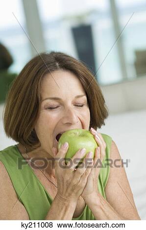 Close-up of a woman eating an apple View Large Photo Image Stock Photo - Close-up of a woman eating an apple. Fotosearch