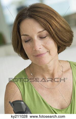Close-up of a woman text messaging on a mobile phone View Large Photo Image Stock Photo - Close-up of a woman text messaging on a mobile phone. Fotosearch