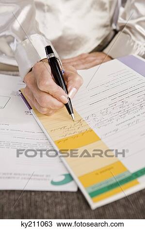 Mid section view of a woman filling out an application form View Large Photo Image Stock Image - Mid section view of a woman filling out an application form. Fotosearch