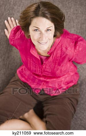 Portrait of a woman sitting on a round sofa and smiling View Large Photo Image Stock Photo - Portrait of a woman sitting on a round sofa and smiling. Fotosearch