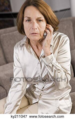 Woman talking on a mobile phone and looking serious View Large Photo Image Stock Photo - Woman talking on a mobile phone and looking serious. Fotosearch
