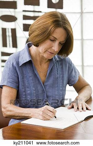 Woman writing in a notebook View Large Photo Image Stock Image - Woman writing in a notebook. Fotosearch