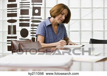 Woman writing in a notebook View Large Photo Image Stock Photograph - Woman writing in a notebook. Fotosearch