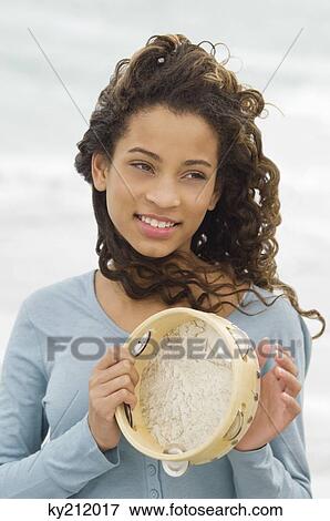 Stock Photo - Close-up of a girl playing a tambourine. Fotosearch