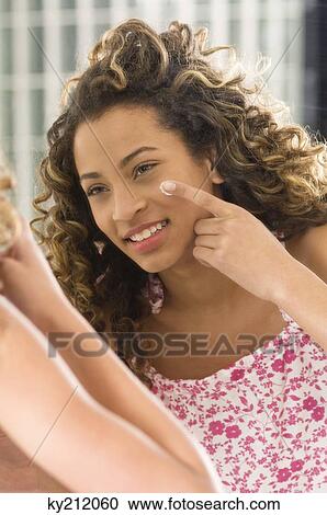 Girl applying moisturizer on her face View Large Photo Image Stock Image - Girl applying moisturizer on her face. Fotosearch